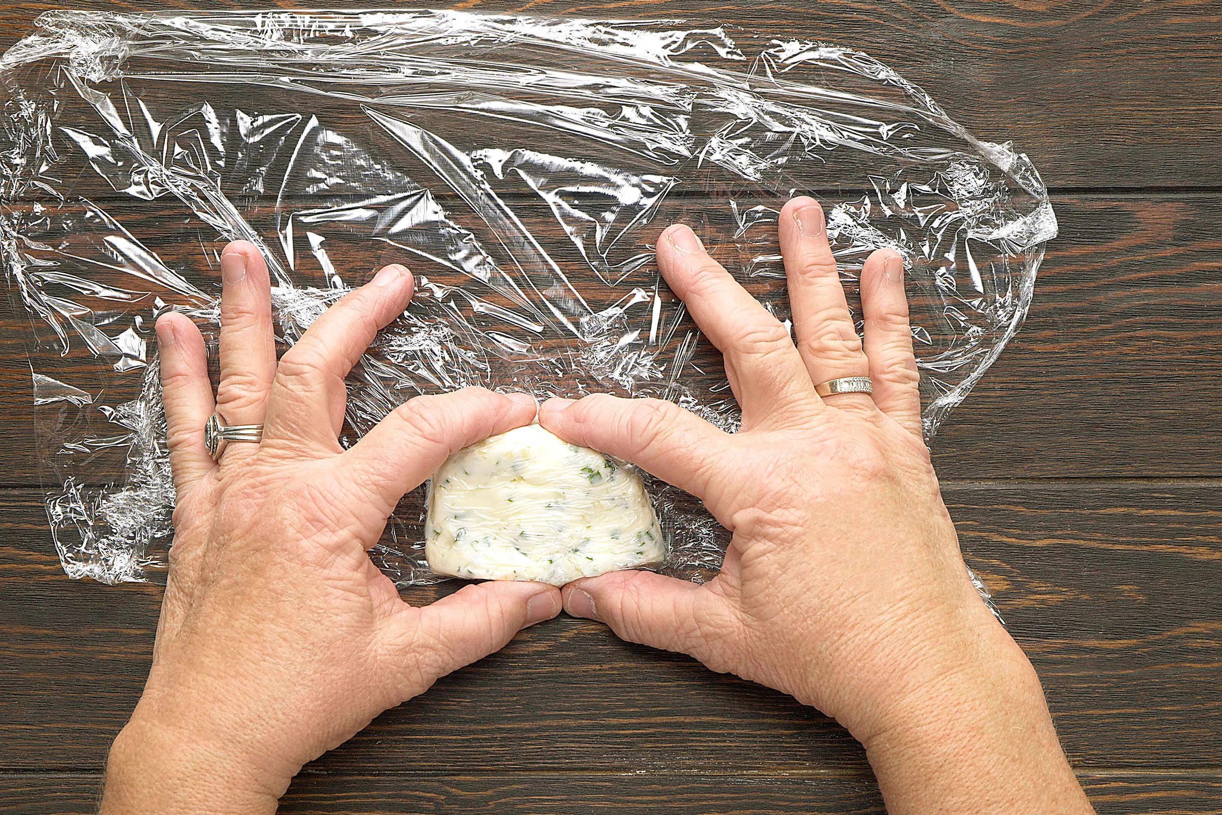 Garlic and chives butter shaped into a rectangle with plastic wrap beneath