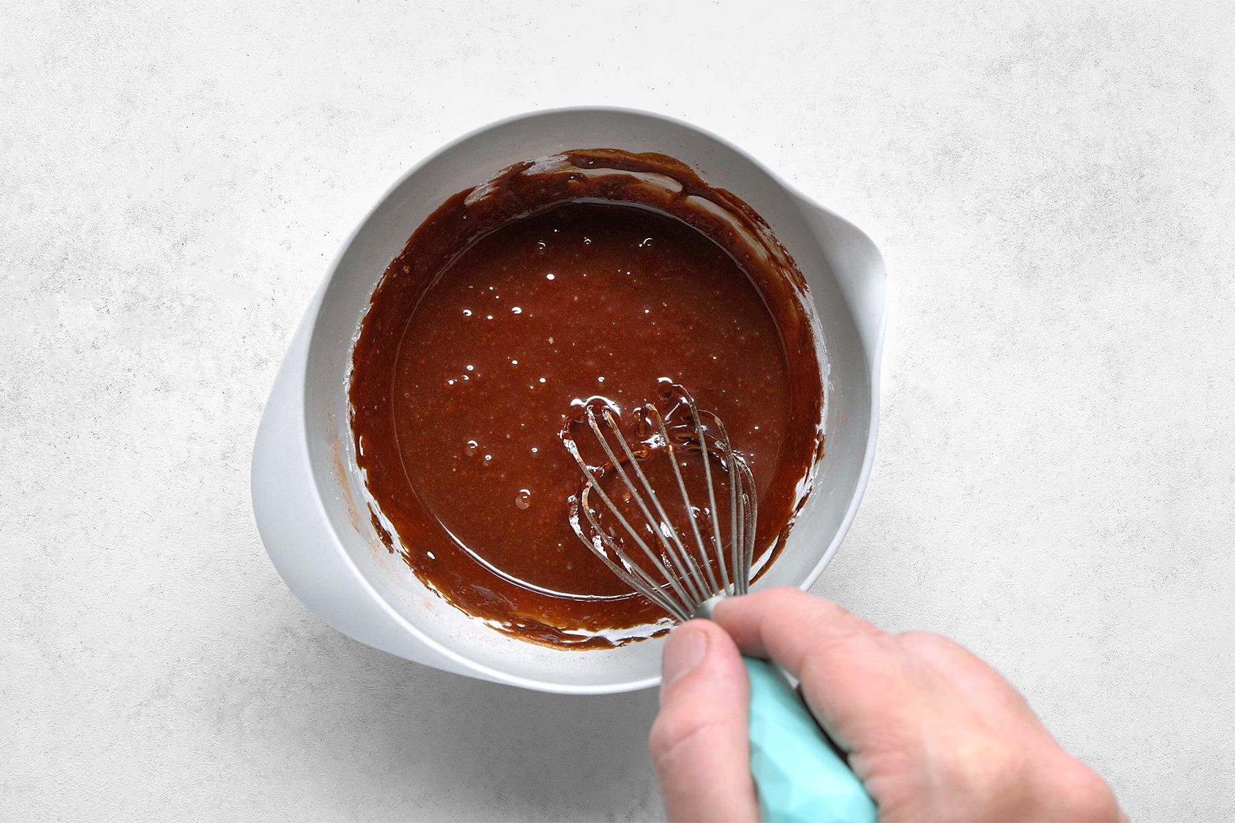 In a large bowl, whisk together water, vanilla extract and cocoa.