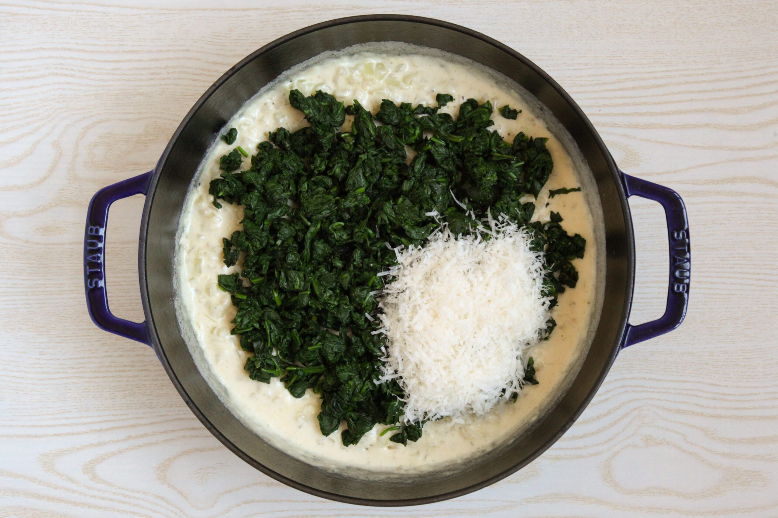 Adding cheese and spinach to creamed spinach base
