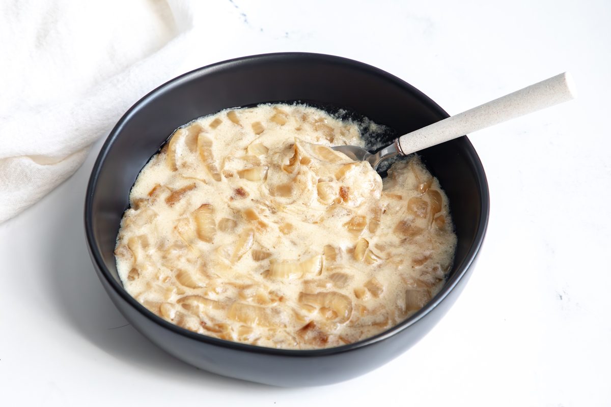 Beauty shot for Taste of Home Creamed Onions being served in a small black bowl.