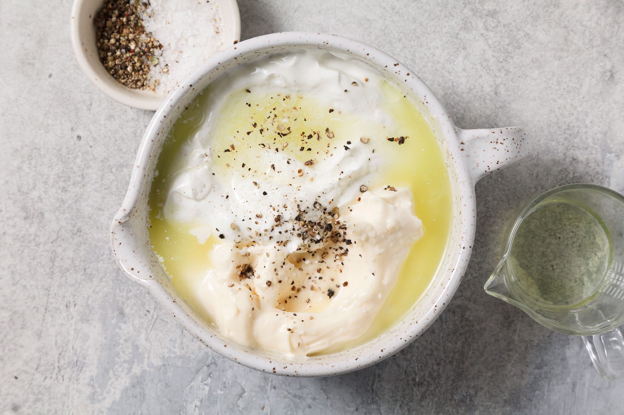 Overhead shot of mix dressing ingredients; grey surface;