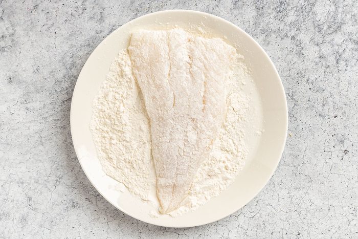 Taste of Home Fried Cod Fish photo of dredging the cod in flour.