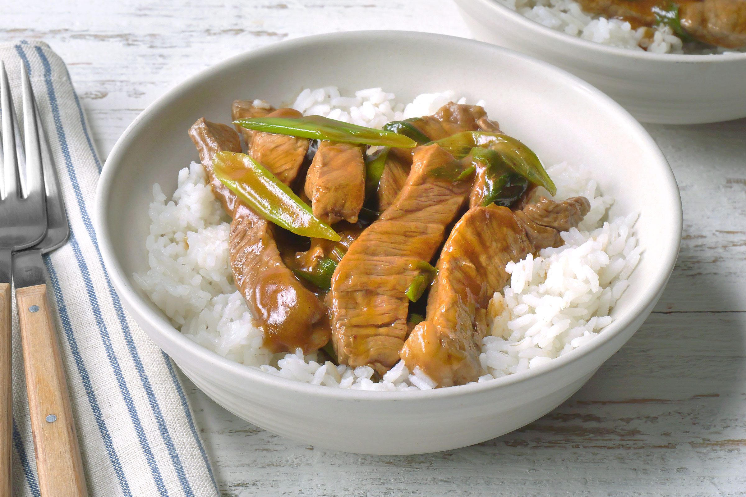 Mongolian Beef served with white rice in a white bowl
