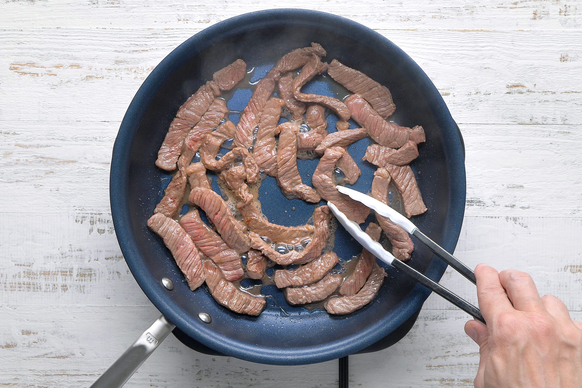 Stir frying the beef strips in a skillet
