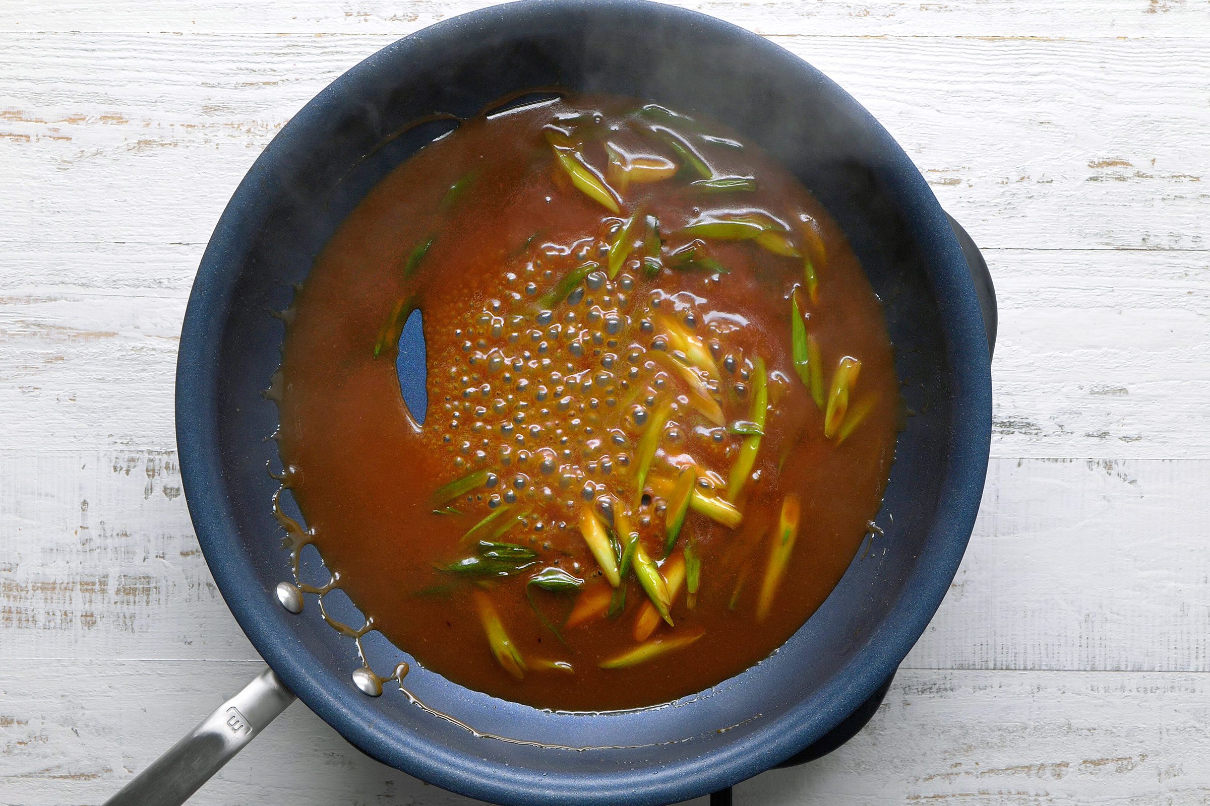 Sauces in stir fried onions in a large skillet