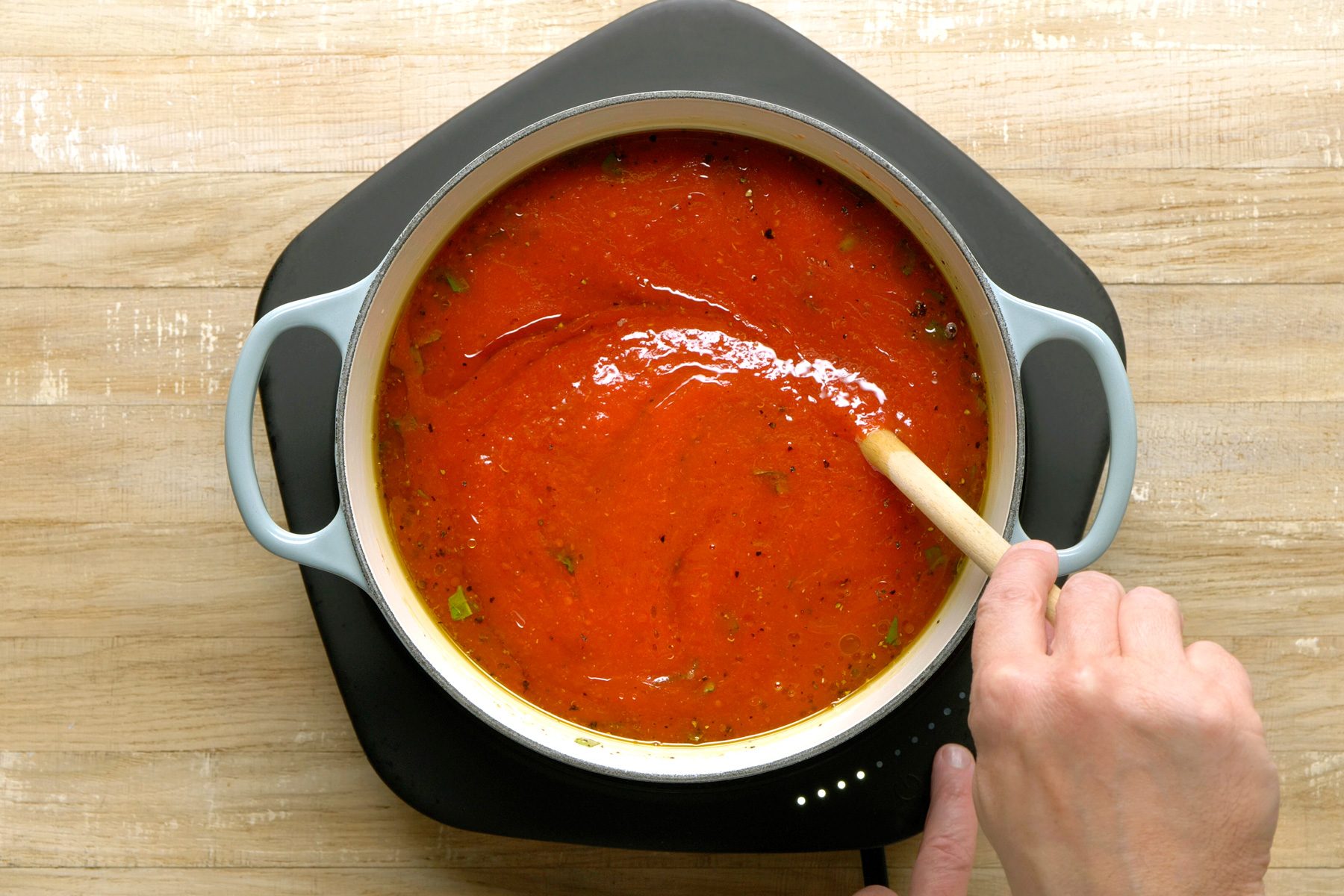 Crushed tomatoes, water, tomato paste, salt, and chopped basil combined in a Dutch oven.
