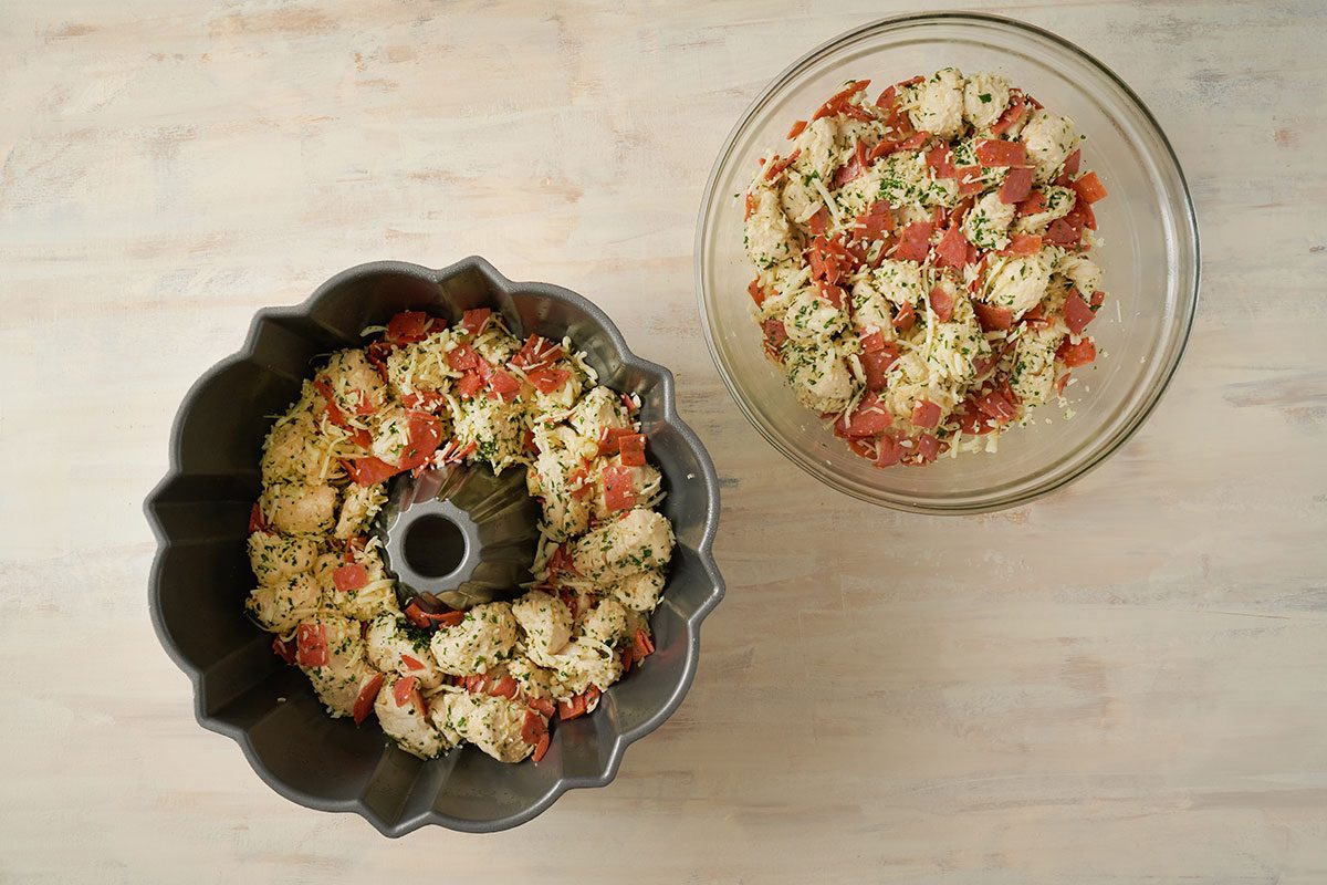 Overhead view of the dough mixture spread in a greased pan and baking in the oven for the Taste of Home Pull Apart Pizza recipe.