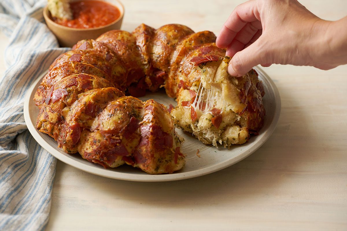 Close-up horizontal shot of the Taste of Home Pull Apart Pizza bread, highlighting the crispy, golden-brown crust and gooey cheese.