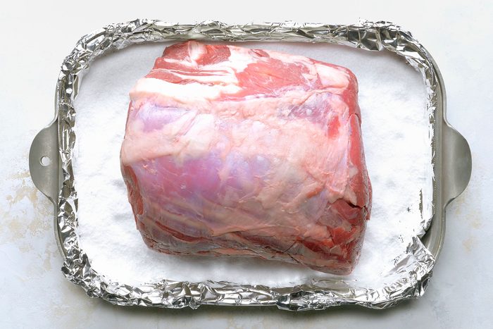 Prime rib on a foiled pan with kosher salt on it