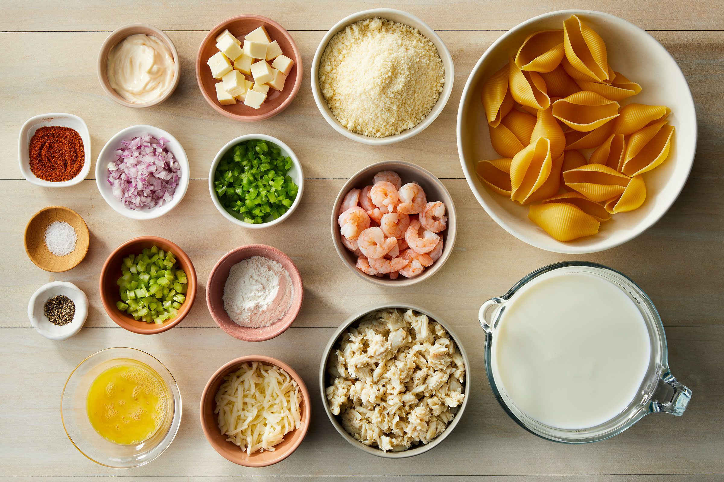 Jumbo pasta shells, Crab, Shrimp, Seafood seasoning, Eggs and mayonnaise, Parmesan cheese sauce in small bowls