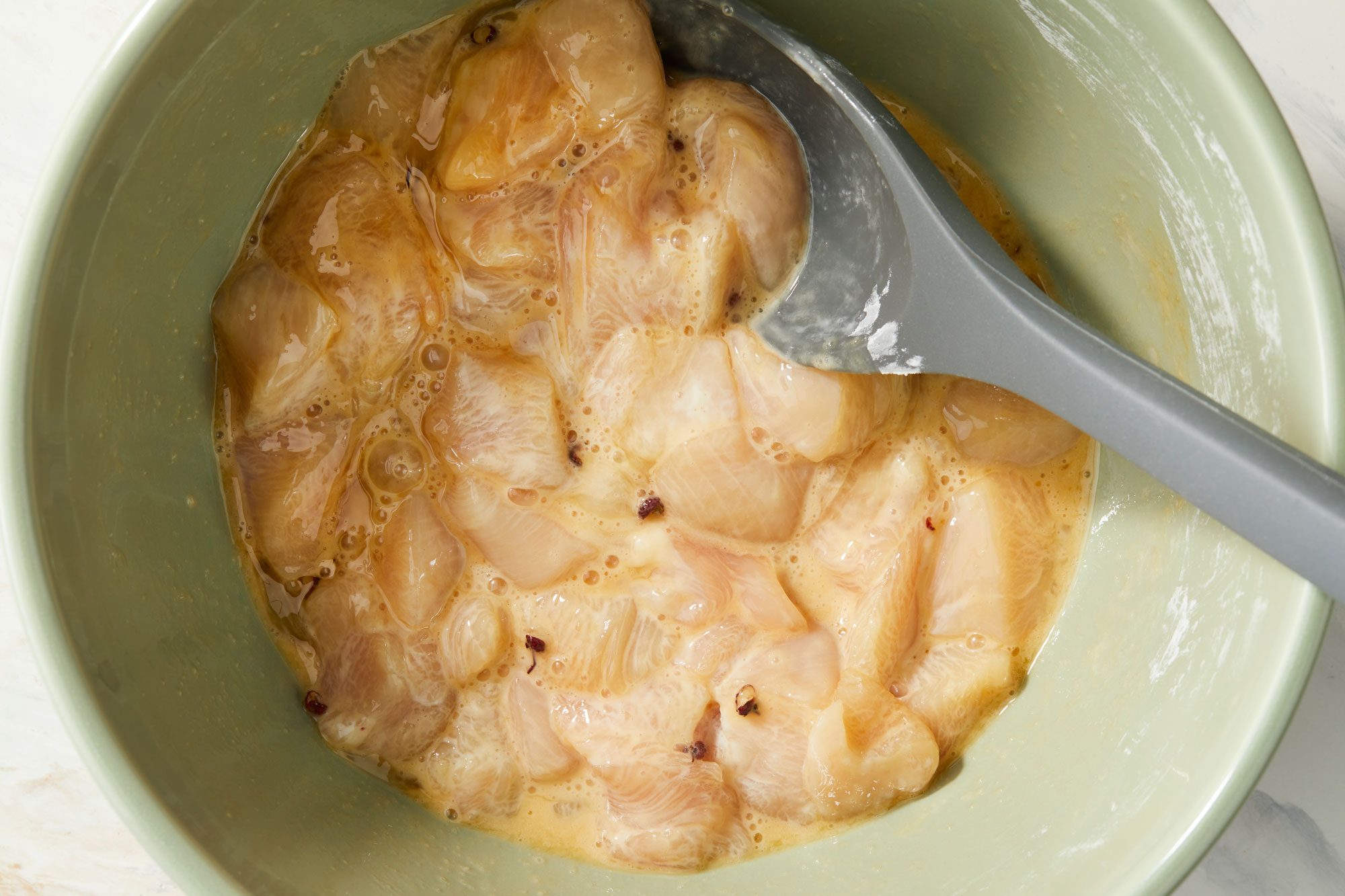 Mixing in egg whites, soy sauce, peppercorns and salt with a spoon