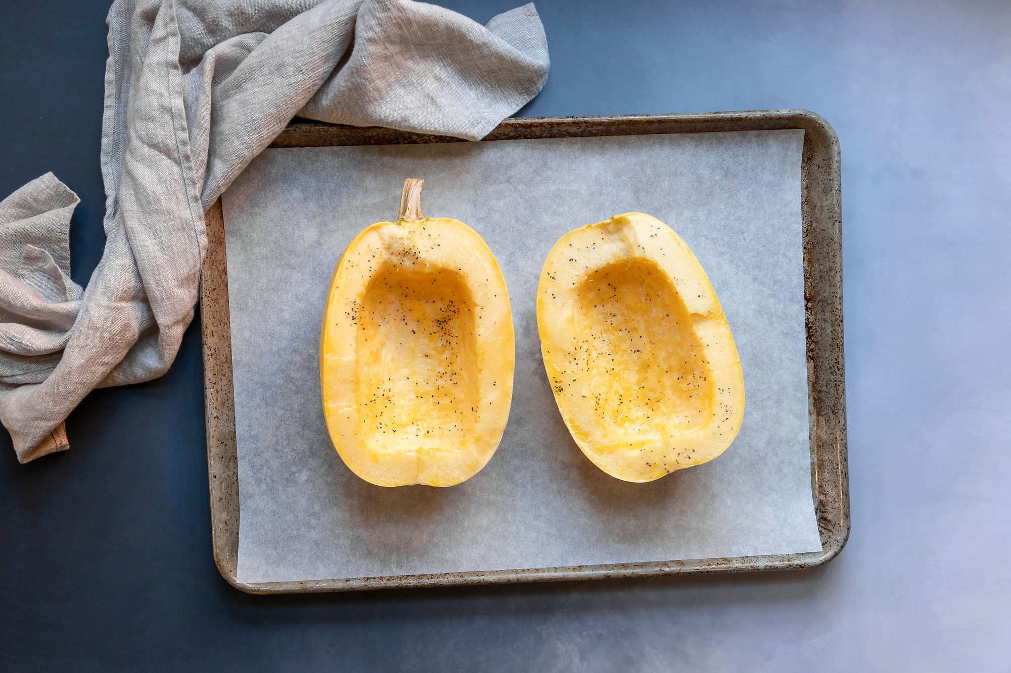 Slice the spaghetti squash in half then sprinkle salt and pepper on oiled surface