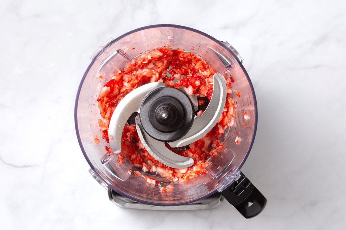 Chopped strawberries in a food processor for step one of Strawberry Butter recipe for Taste of Home
