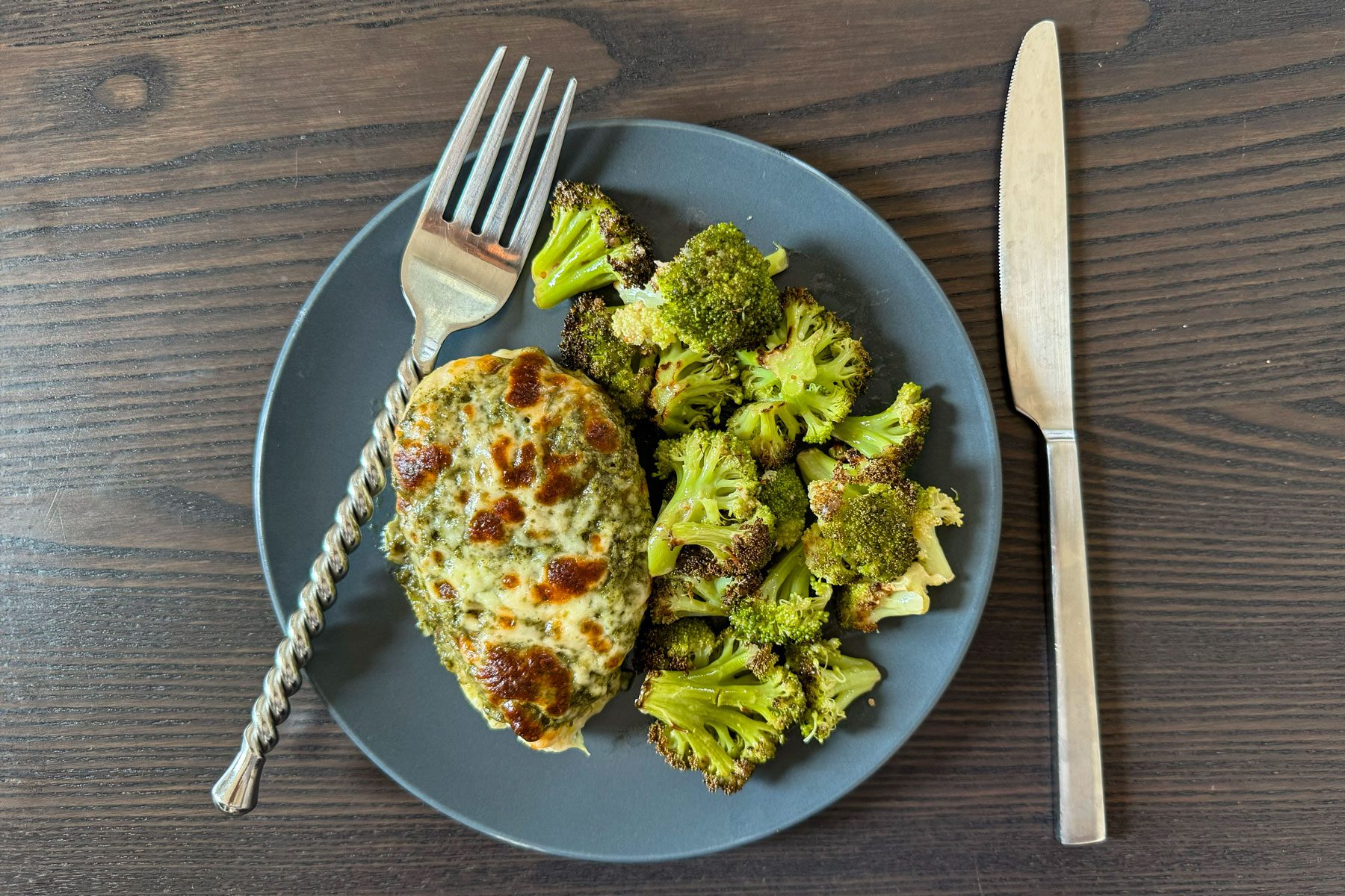 Pesto chicken melt meal on a plate with a knife and a fork
