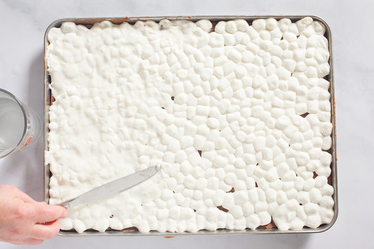 Spreading marshmallows on brownie mix