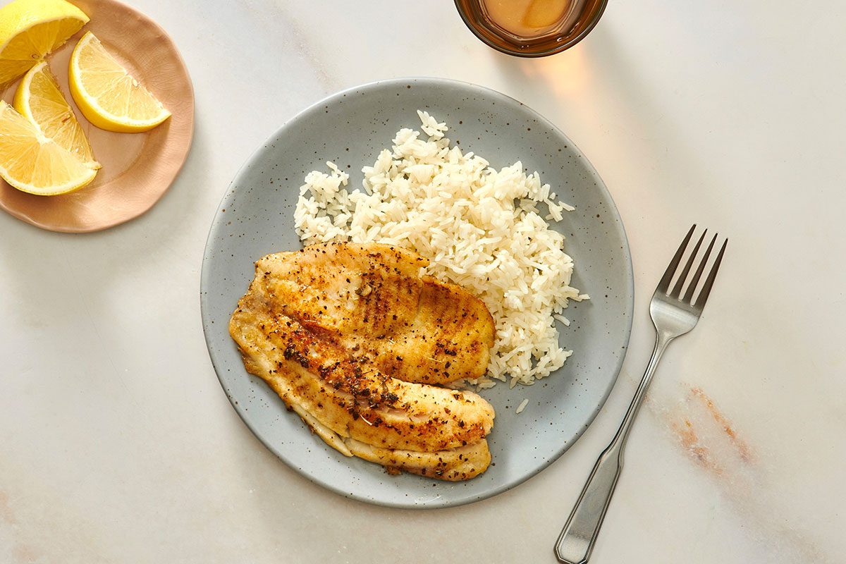 Tilapia fillet served with cooked rice 