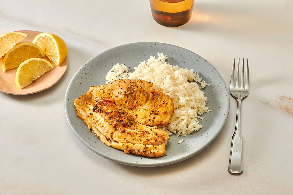 Tilapia fillet served with cooked rice 