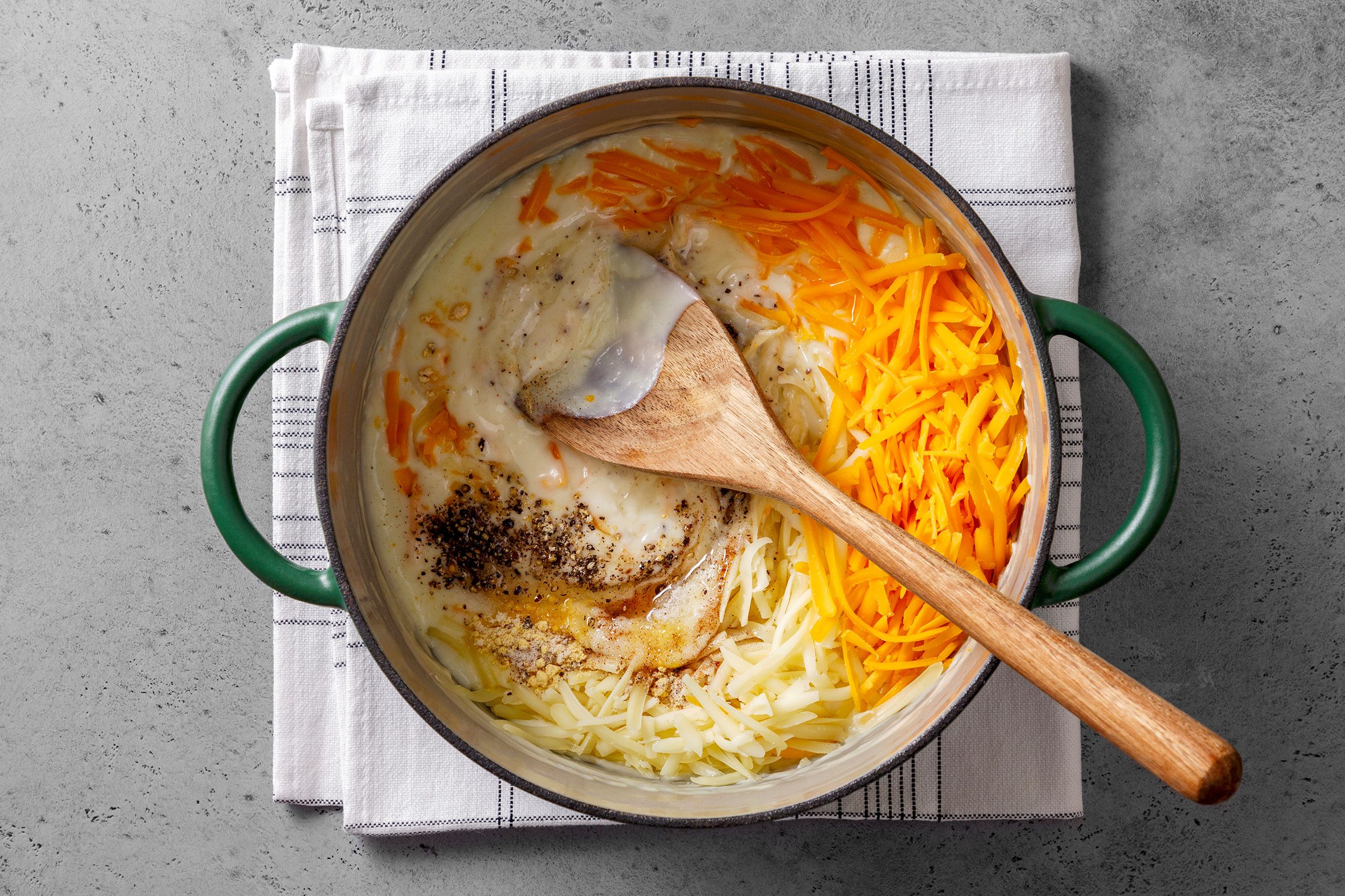 Cheese, salt and seasonings added to the cream sauce in a large saucepot
