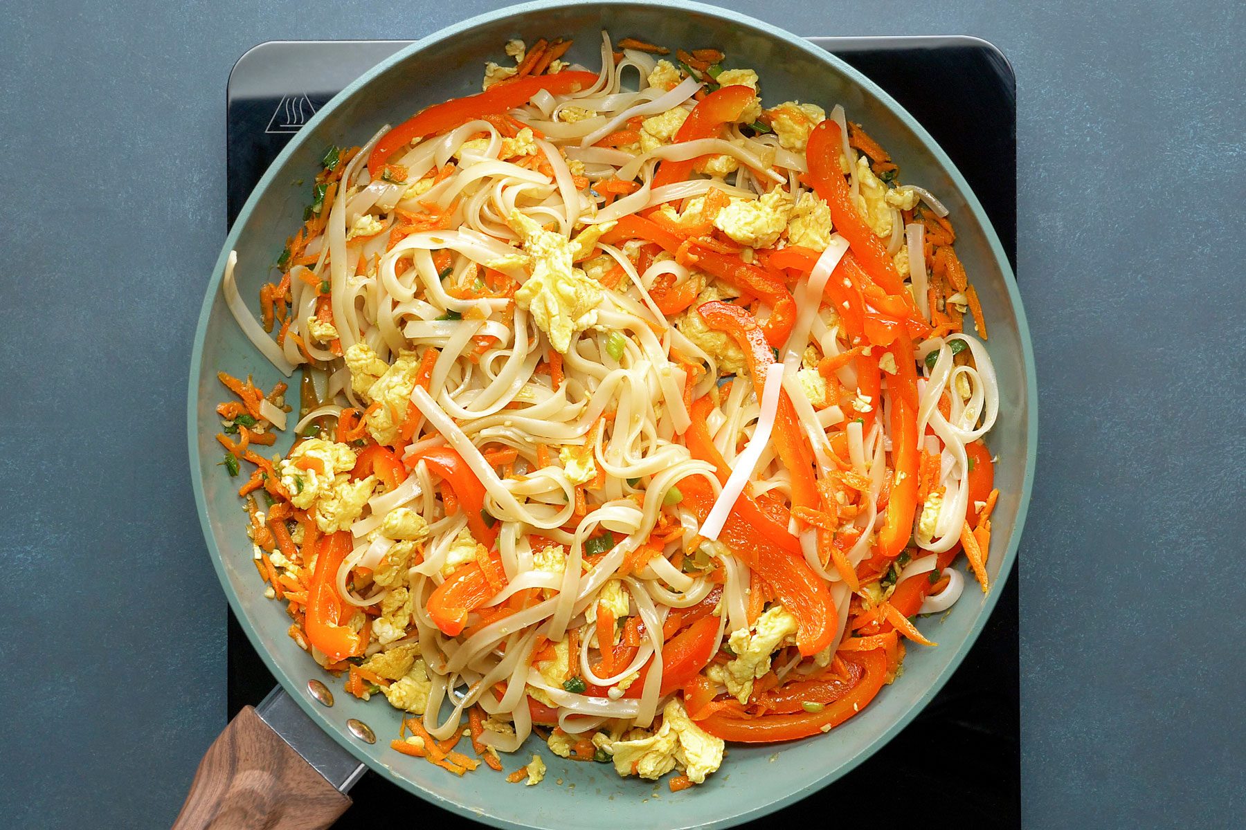 eggs being scrambled with vegetable mixture