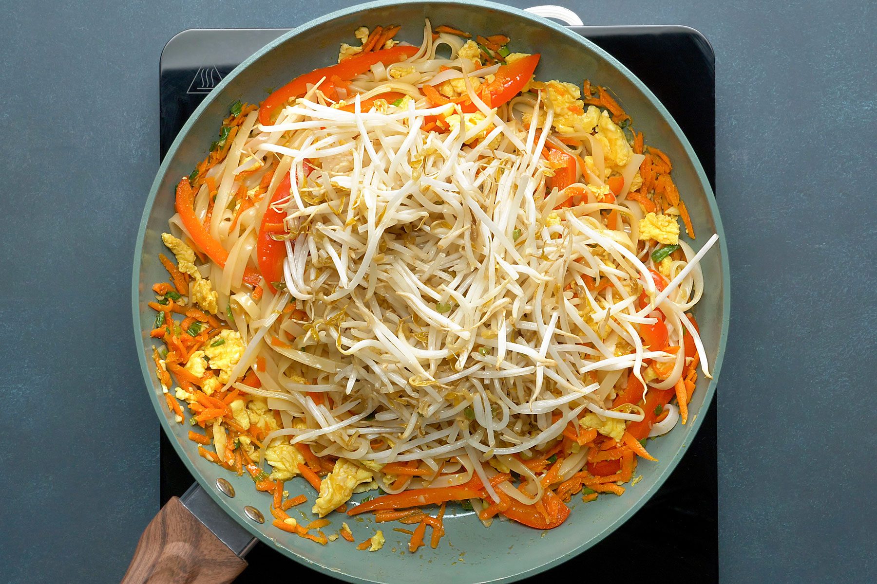 carrot mixture, noodles and sauce being stir fried