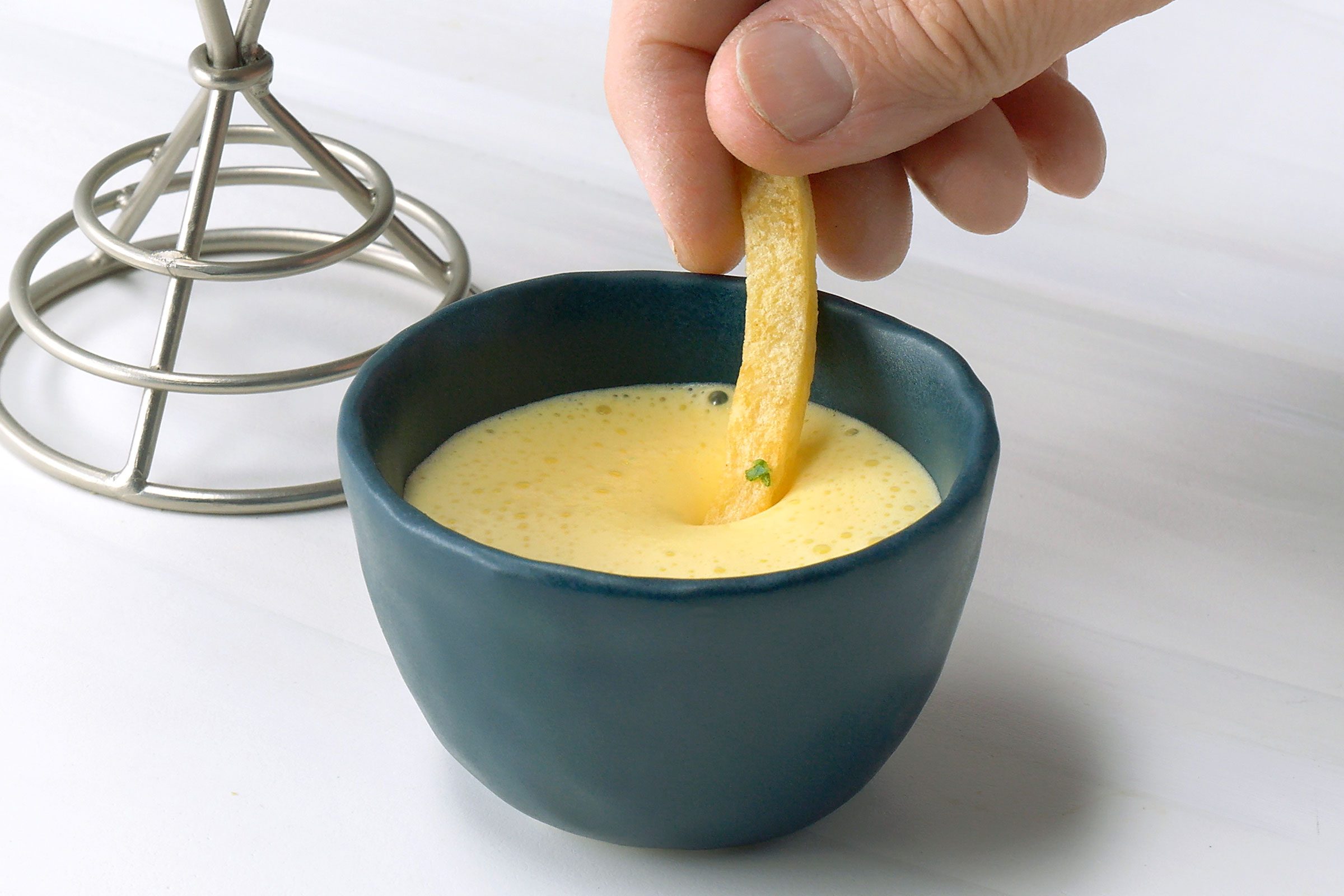 Fries dipped in Aioli in a small bowl