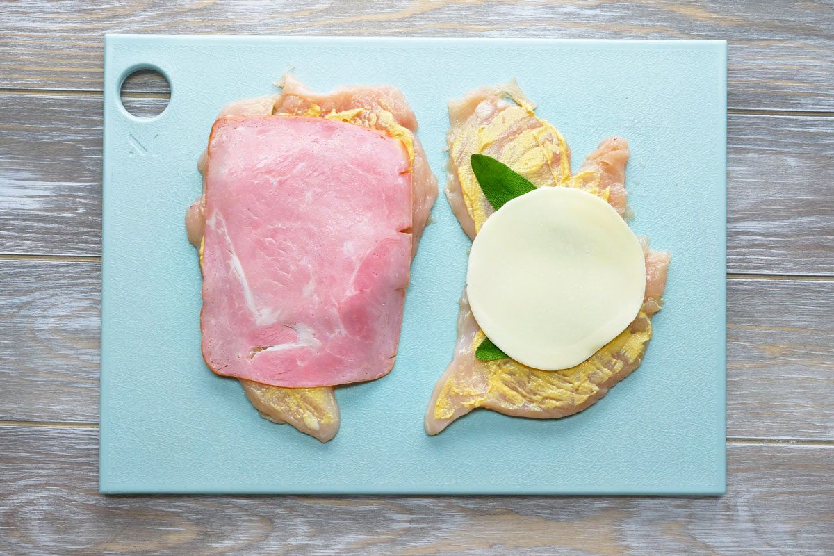 Down the center of each, place 2 sage leaves, 1 cheese slice, 1 ham slice and 4 asparagus spears.