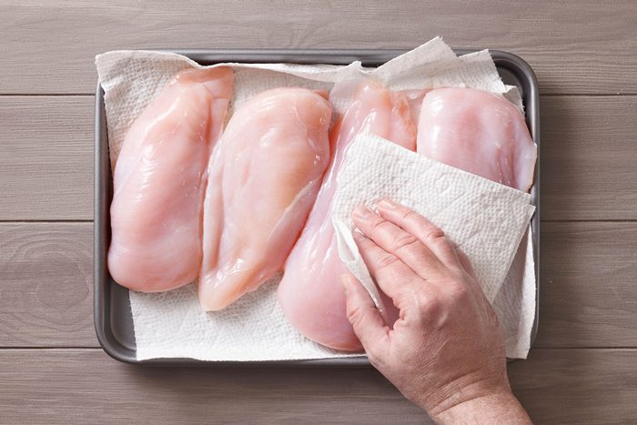 Patting chicken breasts with dry paper towel