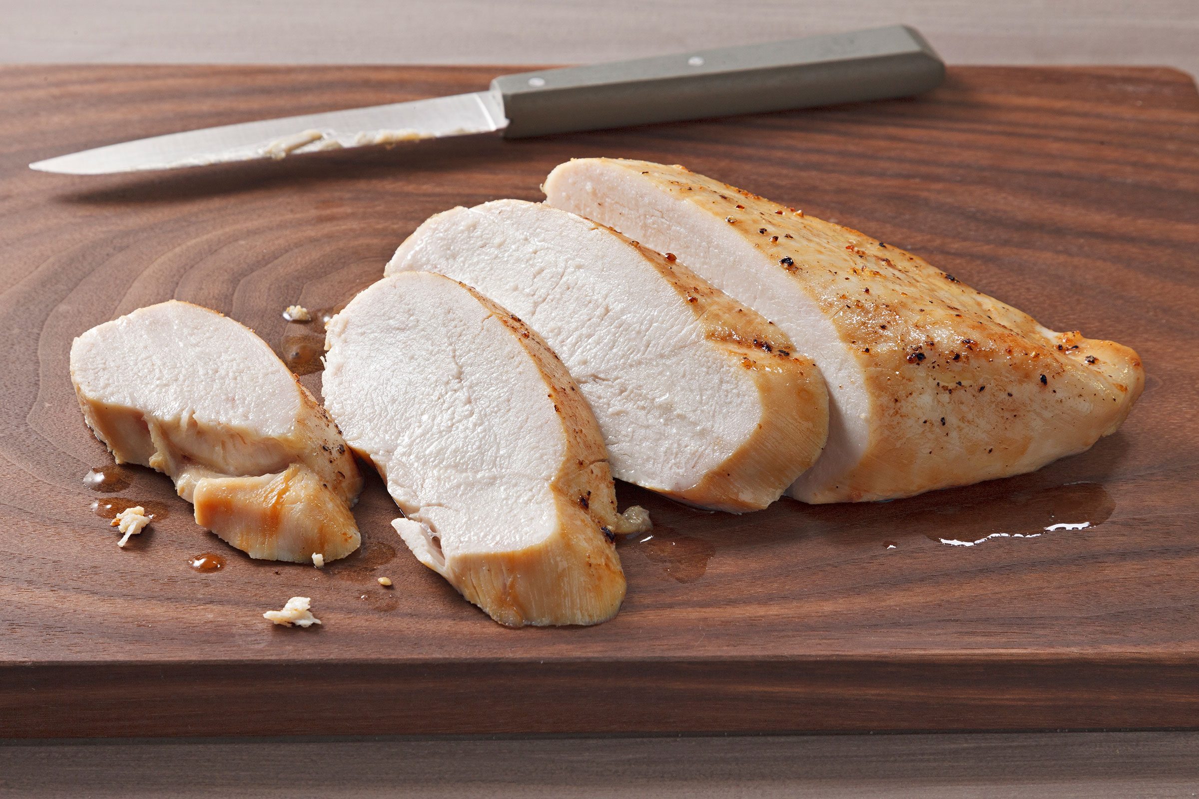 Chicken Breasts baked and cut into pieces on a wooden board