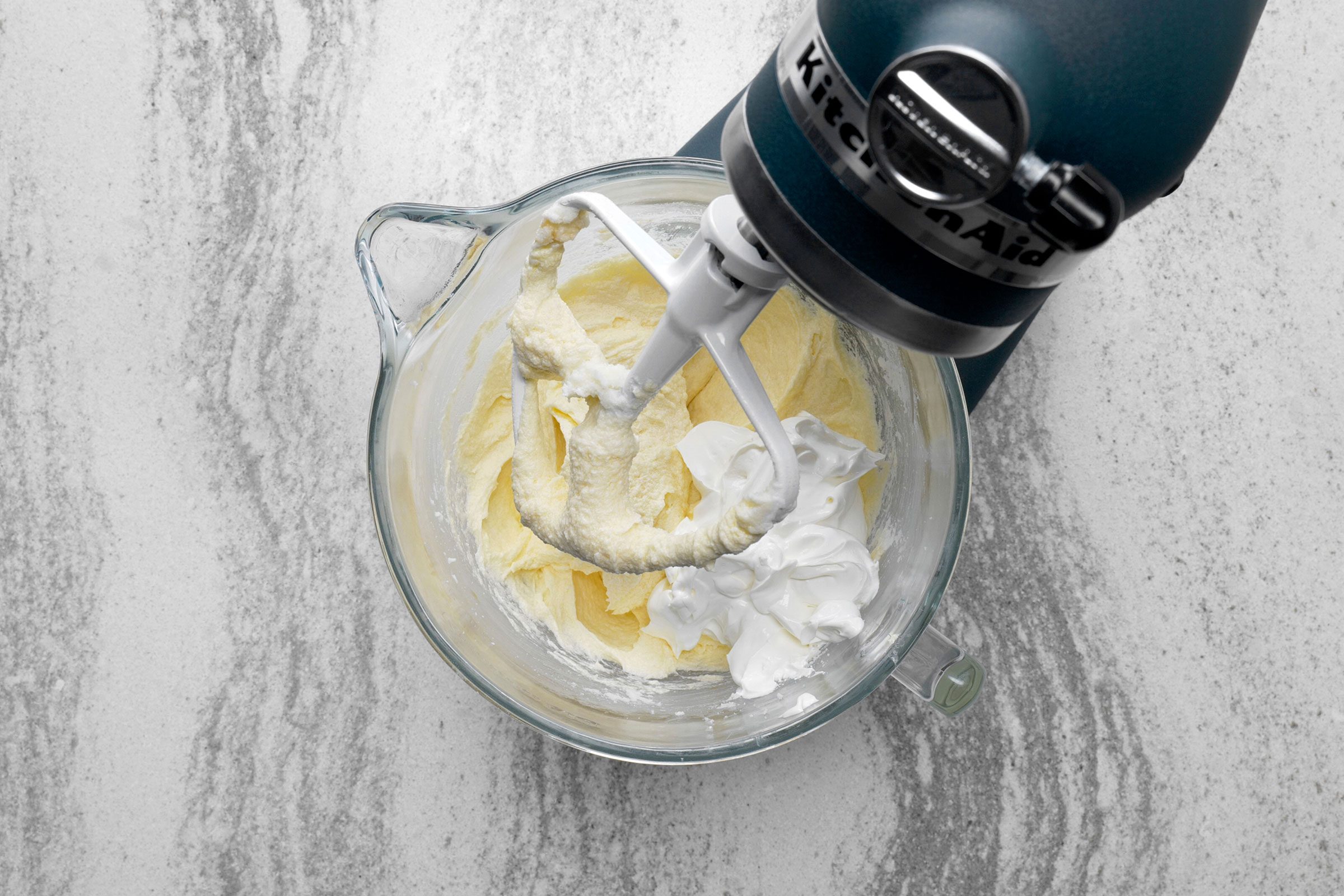 Sour cream added to butter and sugar mixture in a large bowl