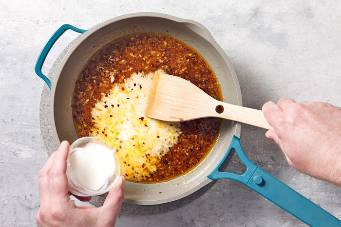 Heat canola oil in a large skillet to medium-high heat. Add red pepper flakes, garlic and ginger;