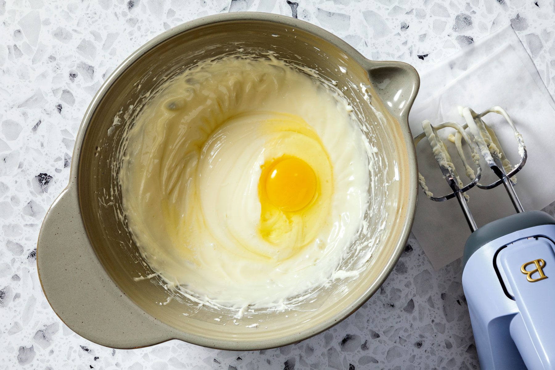 eggs being added to cream cheese filling