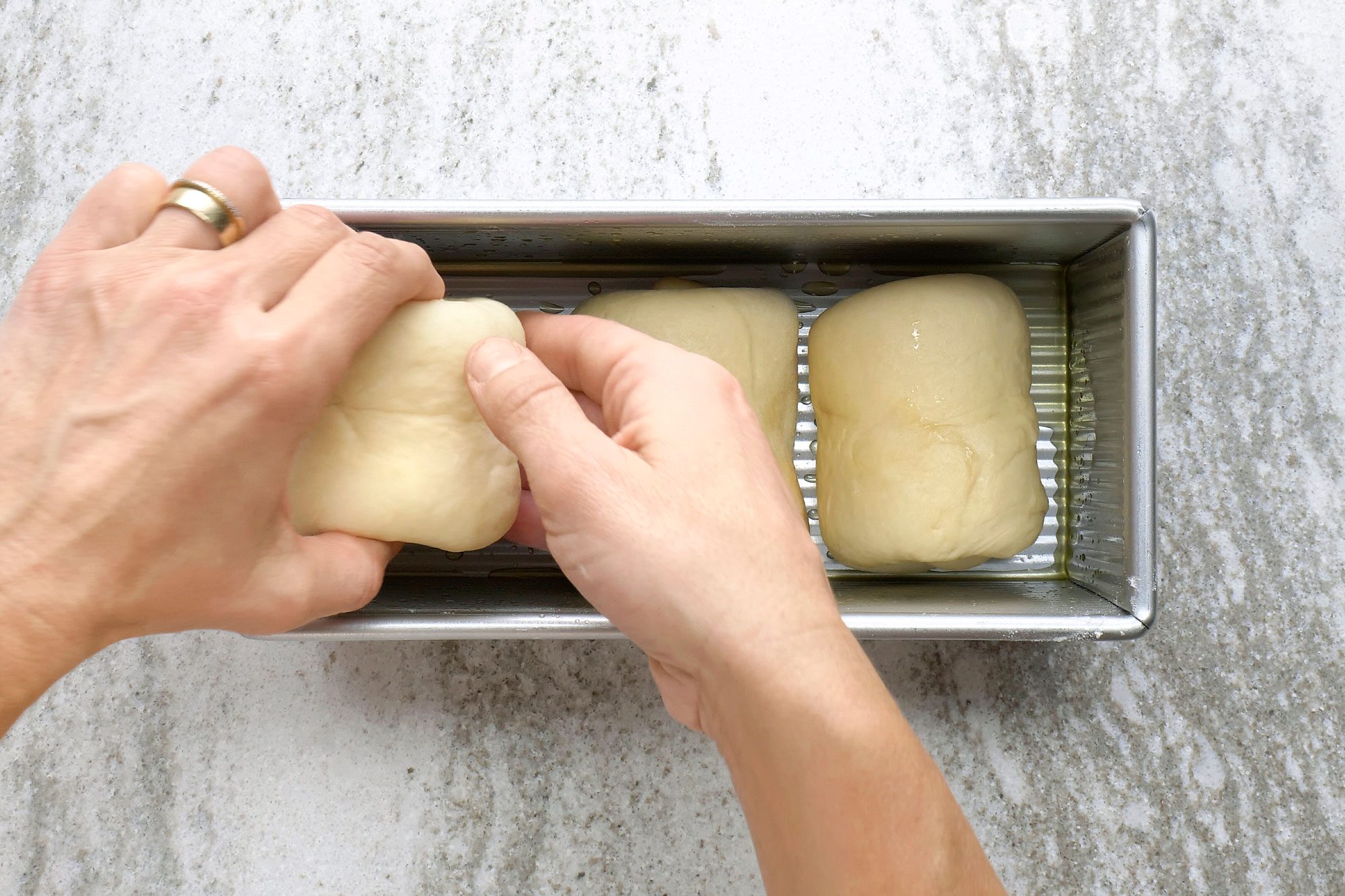 Place the rolled doughs into a greased 9x5-inch loaf pan, seam sides down