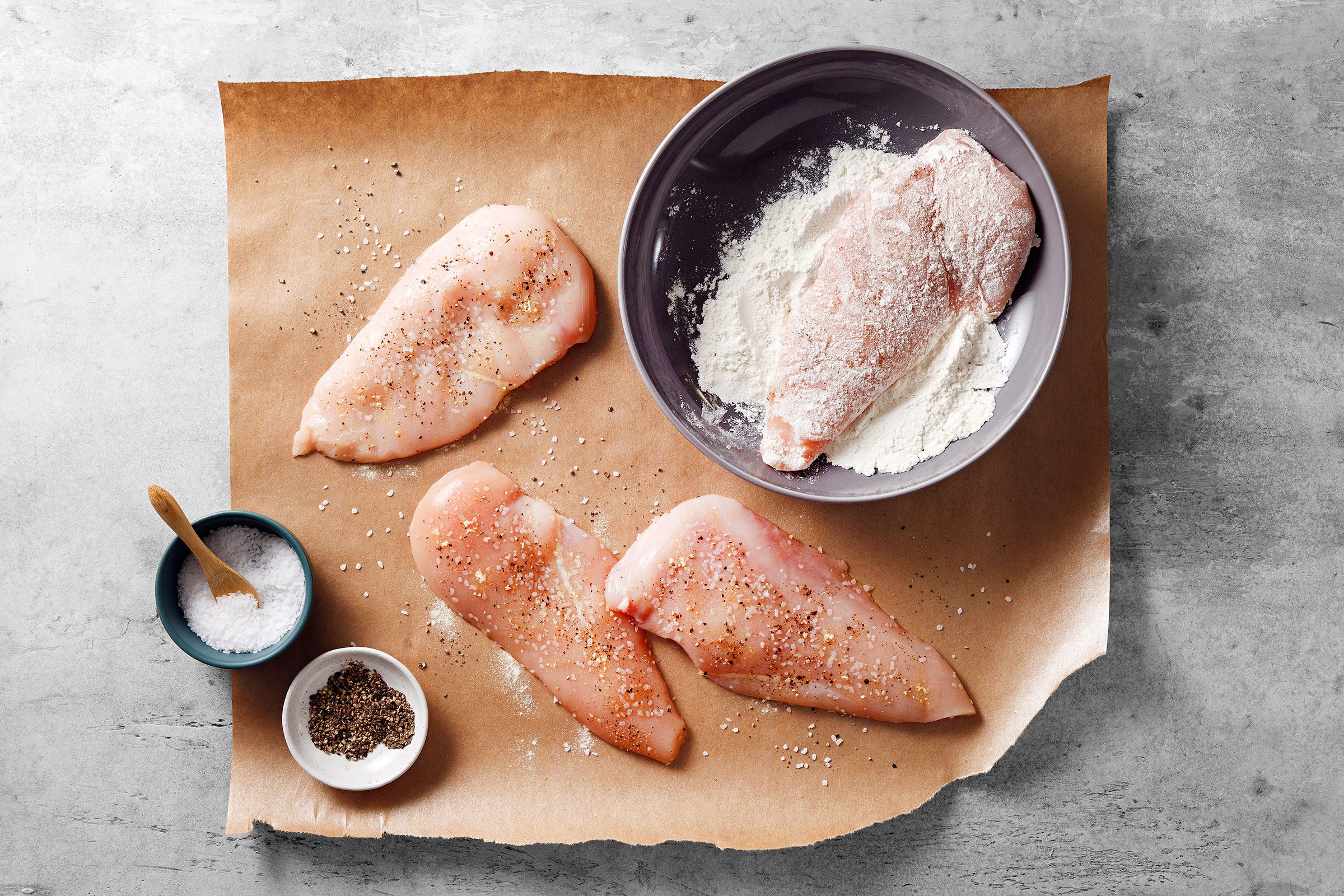 Chicken breasts seasoned with salt and pepper and rolled into flour