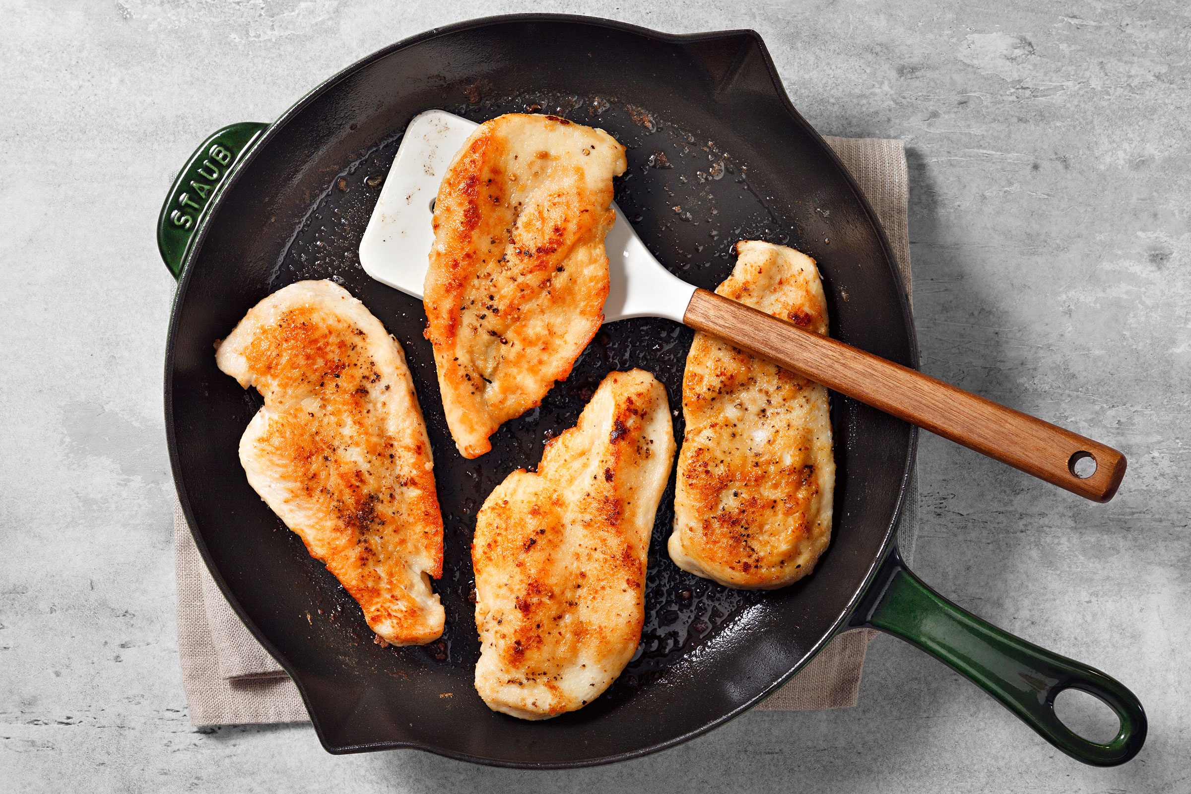 Cooking chicken breasts to golden brown in a large skillet