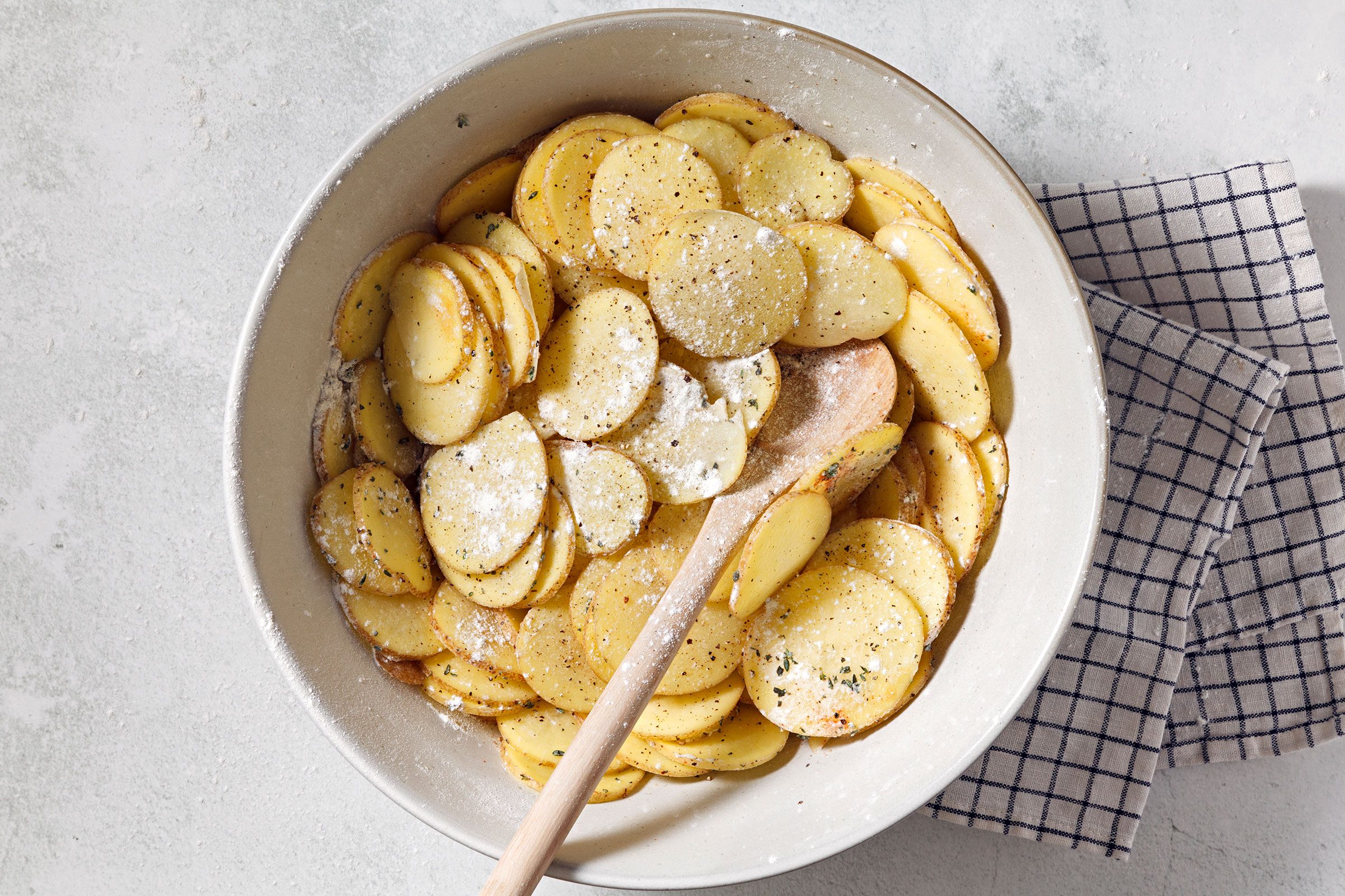 Combined flour, seasonings and sliced potatoes in a large bowl