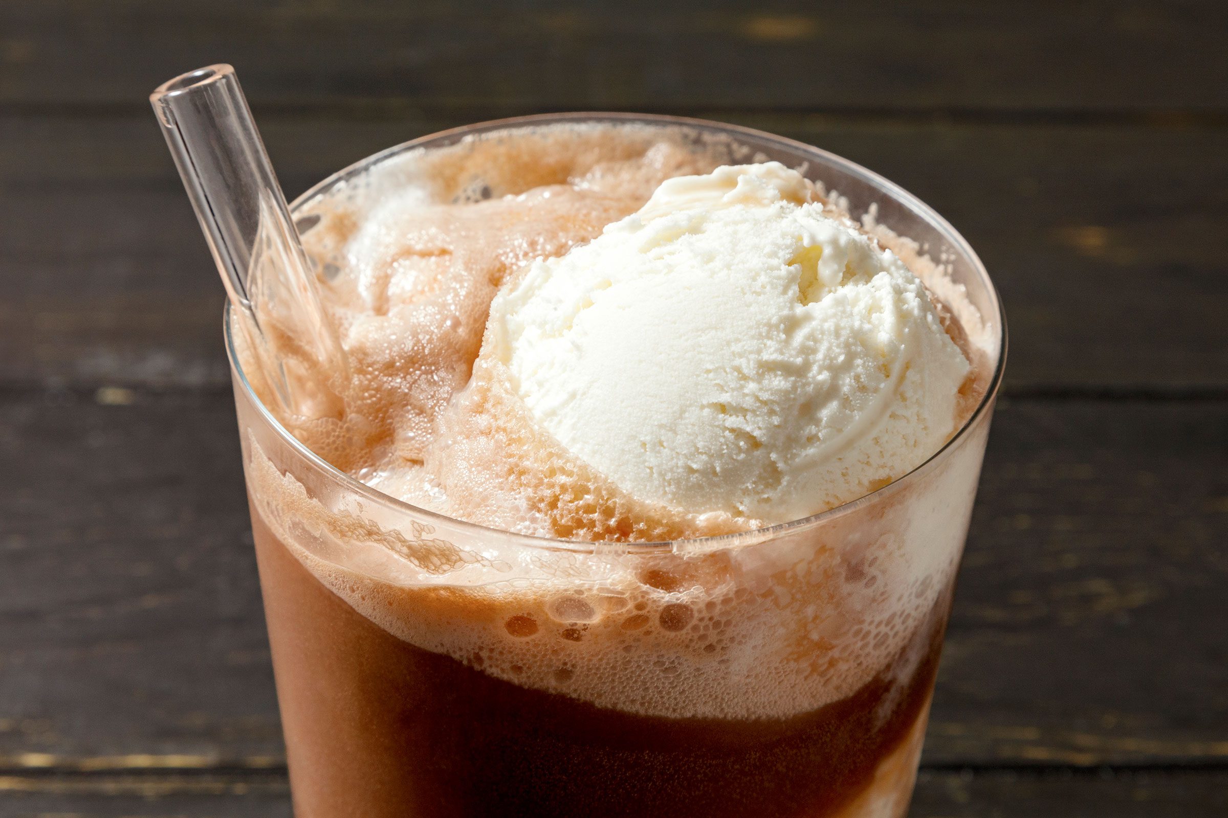 Root Beer Float drink in a glass with a transparent glass straw