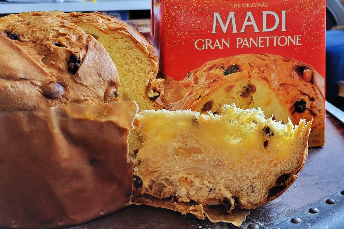A sliced panettone in front of its box