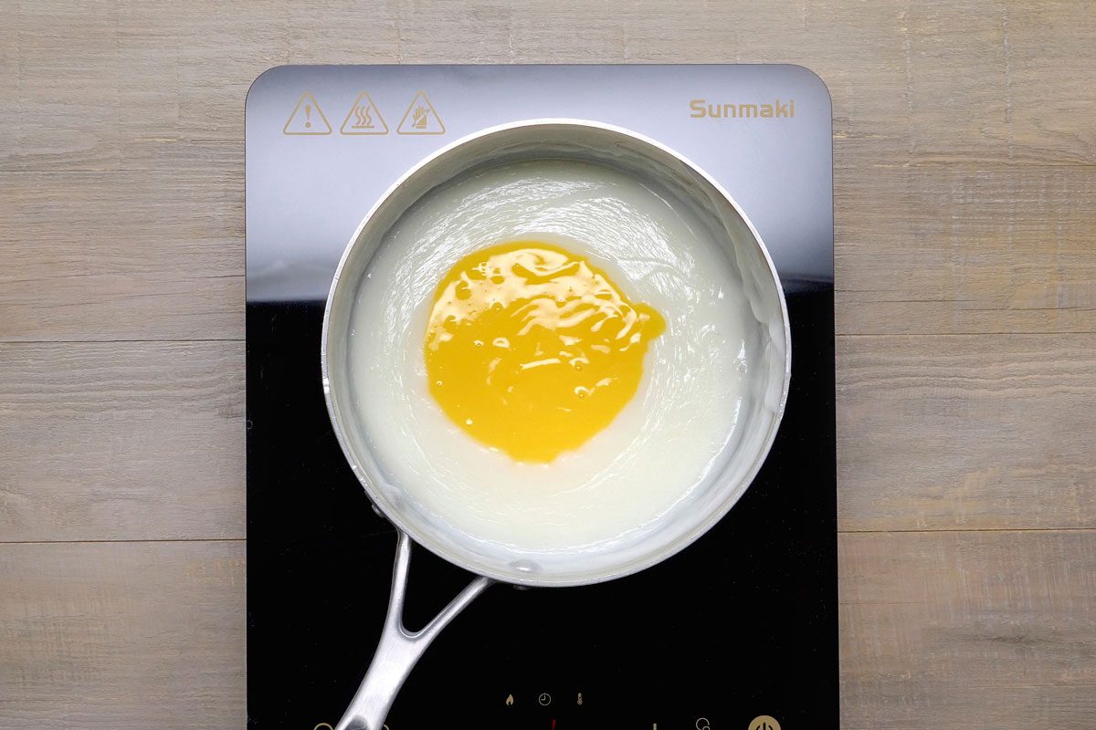 In a small bowl, whisk a small amount of hot mixture into egg yolks