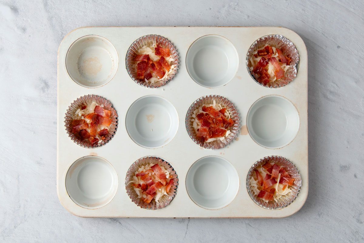 Divide Swiss cheese and bacon among the muffin cups. Pour egg mixture over top.