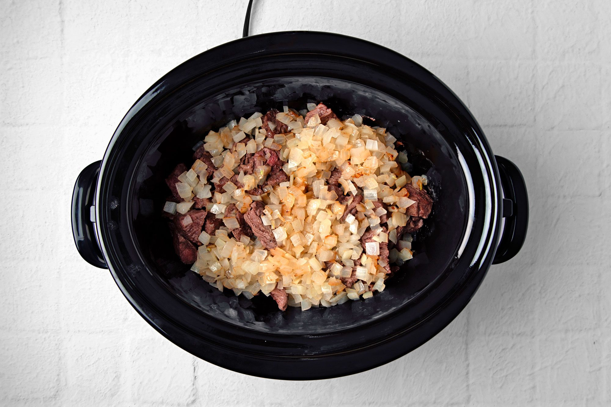 Add beef and onions in slow cooker