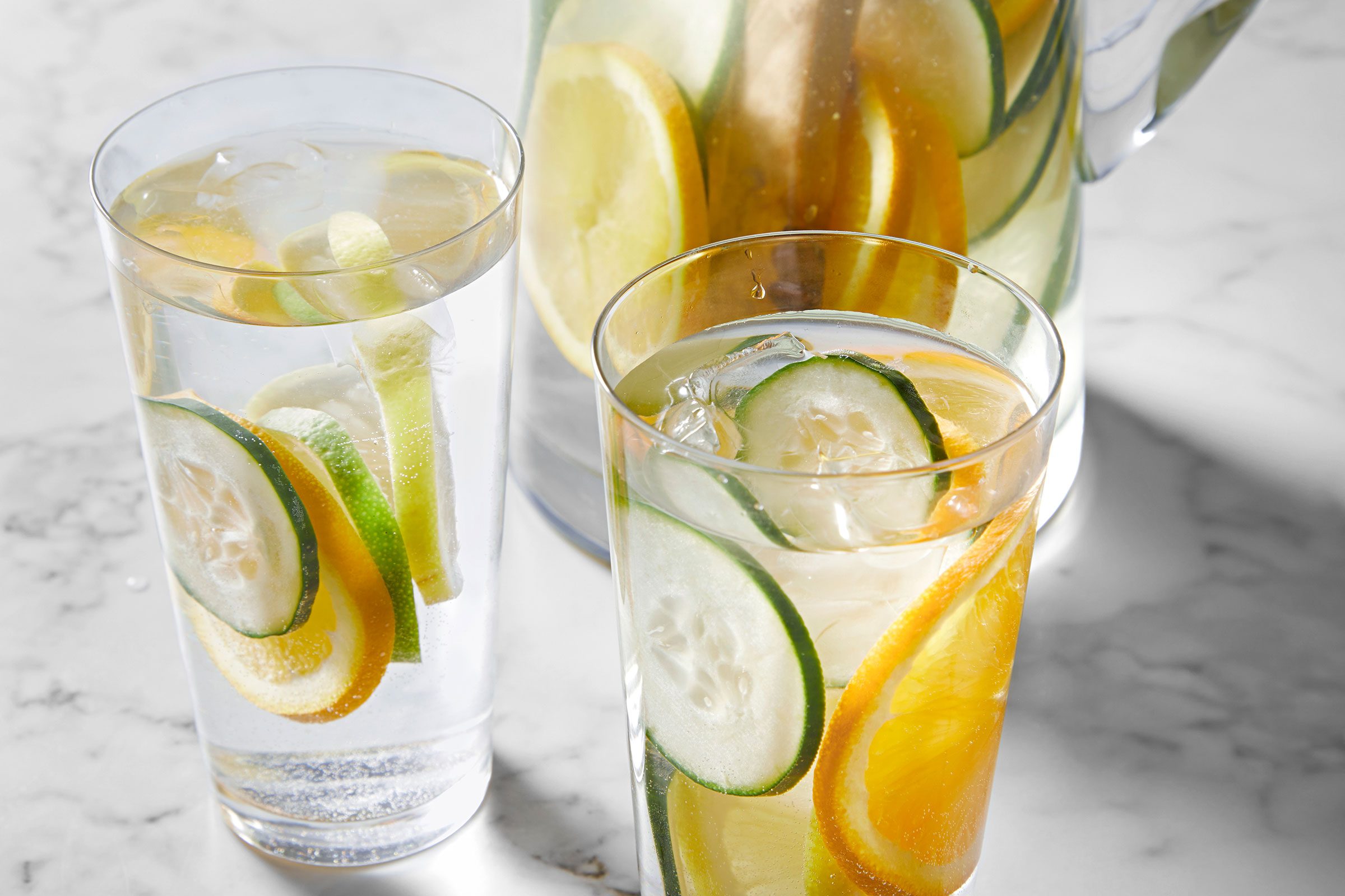 Cucumber Water served in two glass jars with lemon, cucumber and orange slices in it