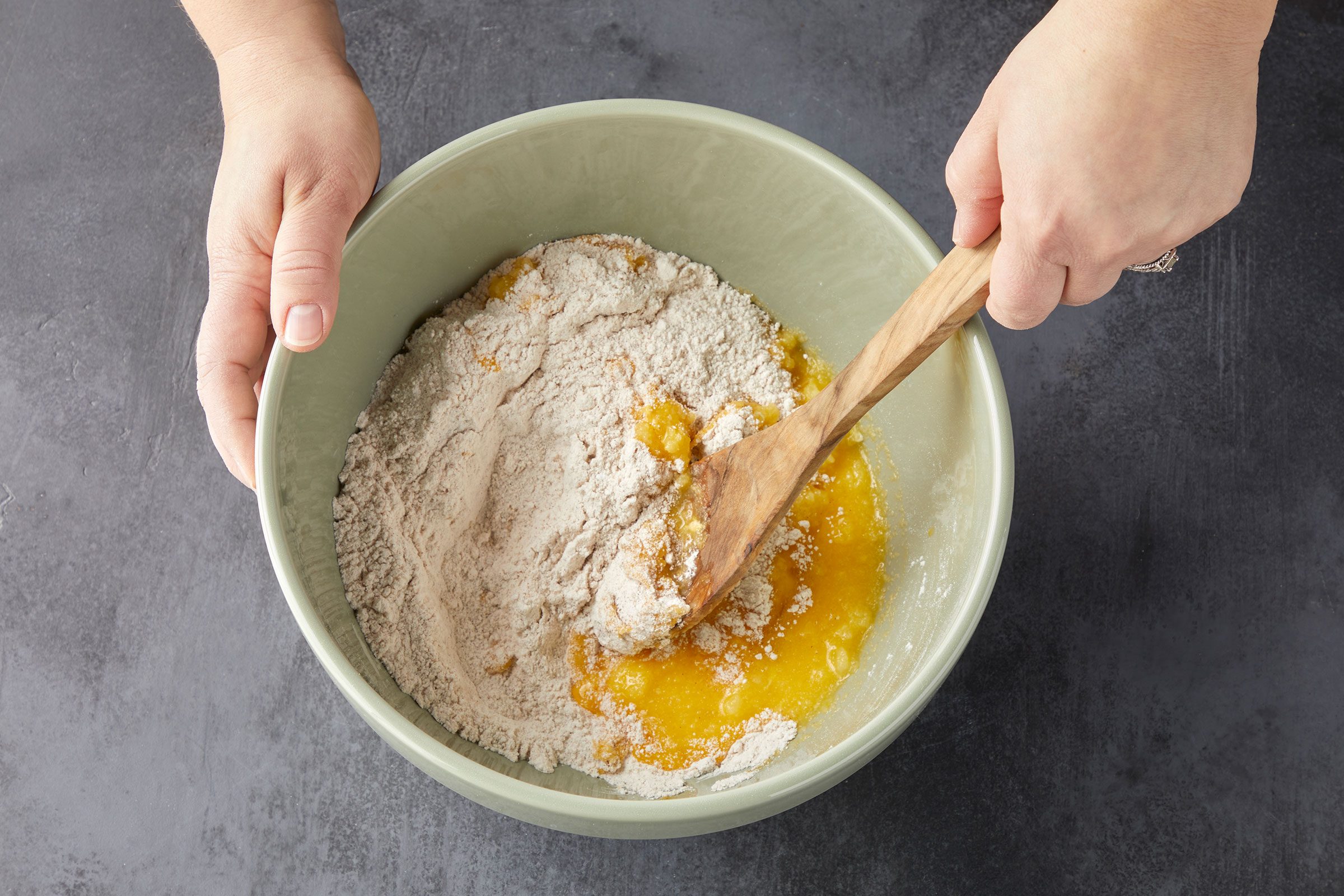 Mixing egg mixture into flour mixture to make cookie dough