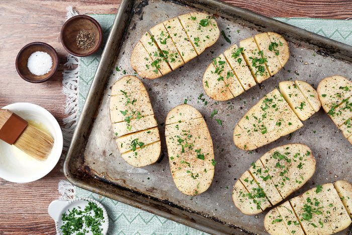 potatoes in a shallow baking dish sprinkled with paprika, parsley, salt and pepper