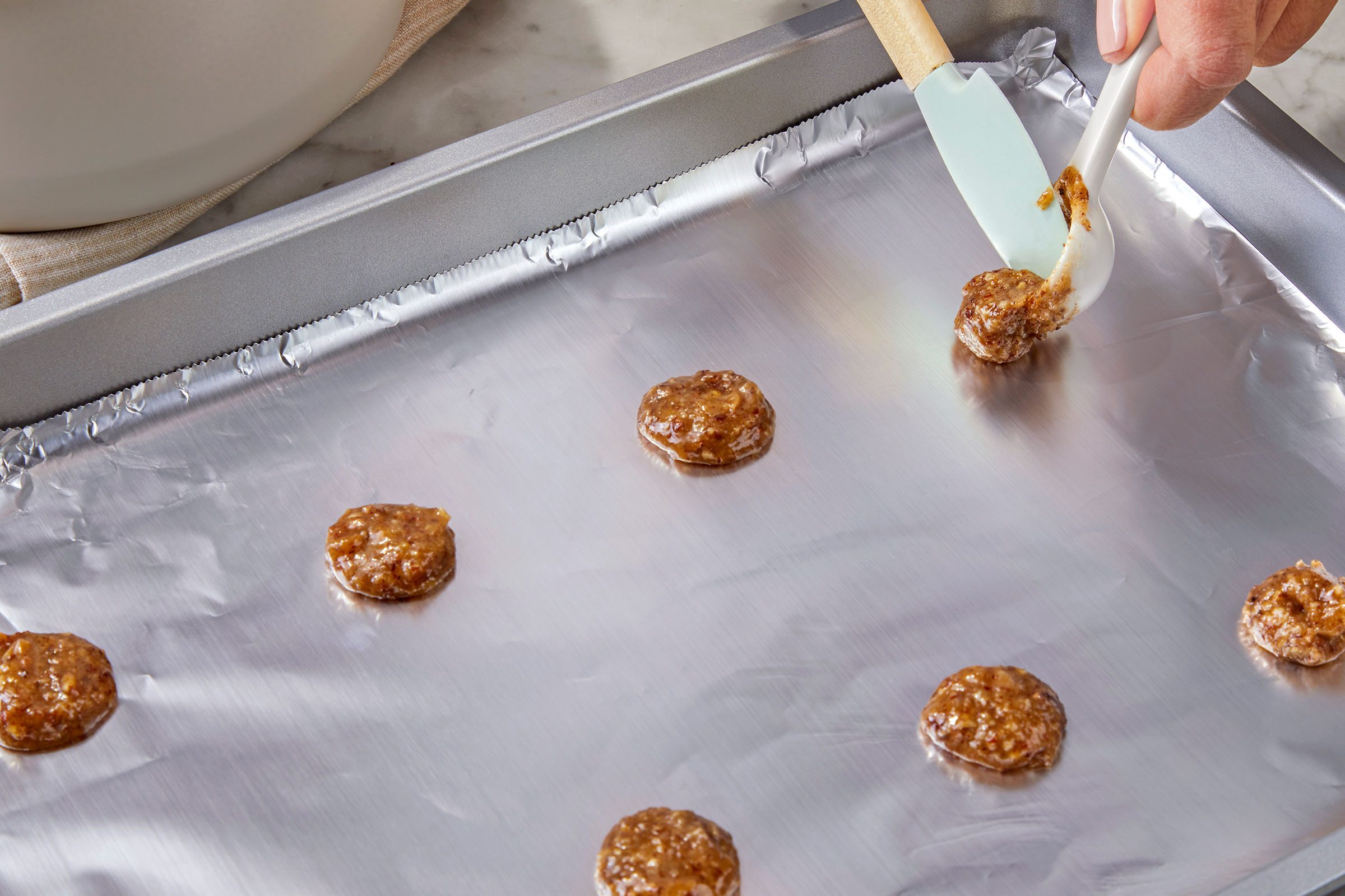 Dropping cookie dough onto foil lined baking dish