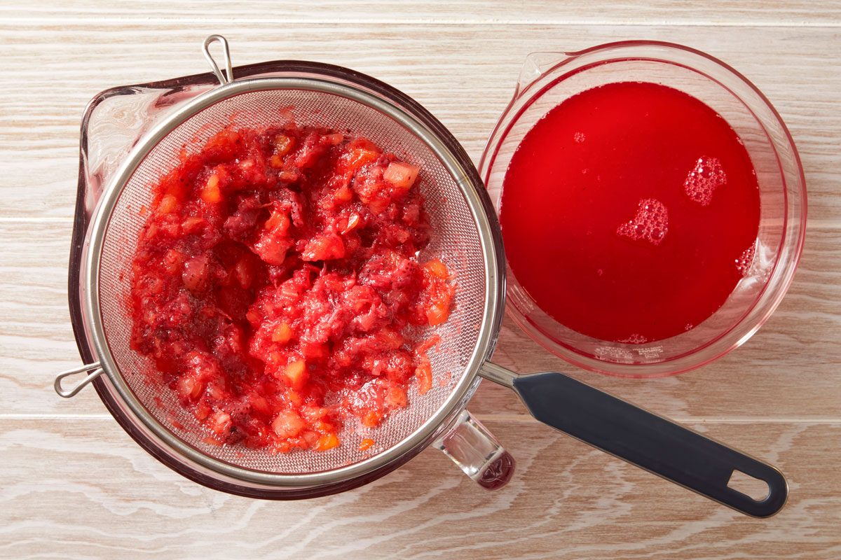 Strain, reserving liquid and fruit.