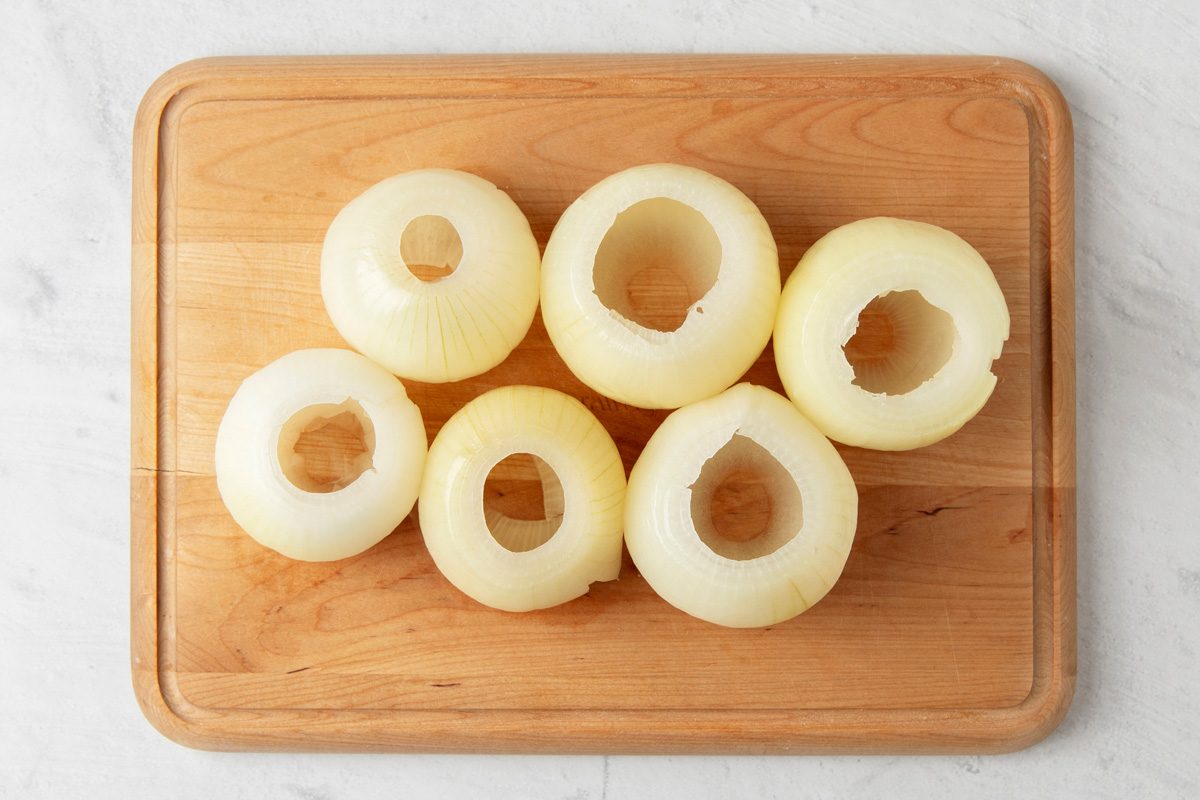 sliced and emptied out onions on a wooden surface