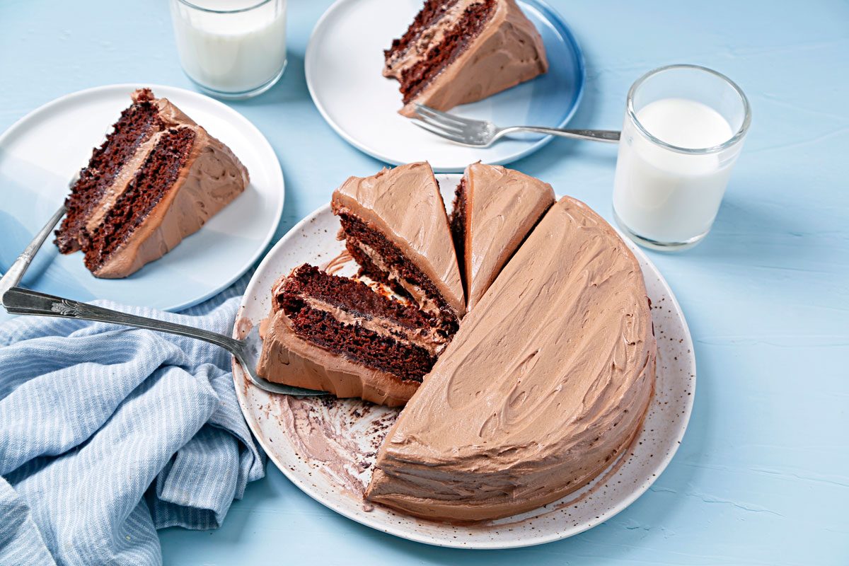 Vegan chocolate cake sliced and served on blue plates.