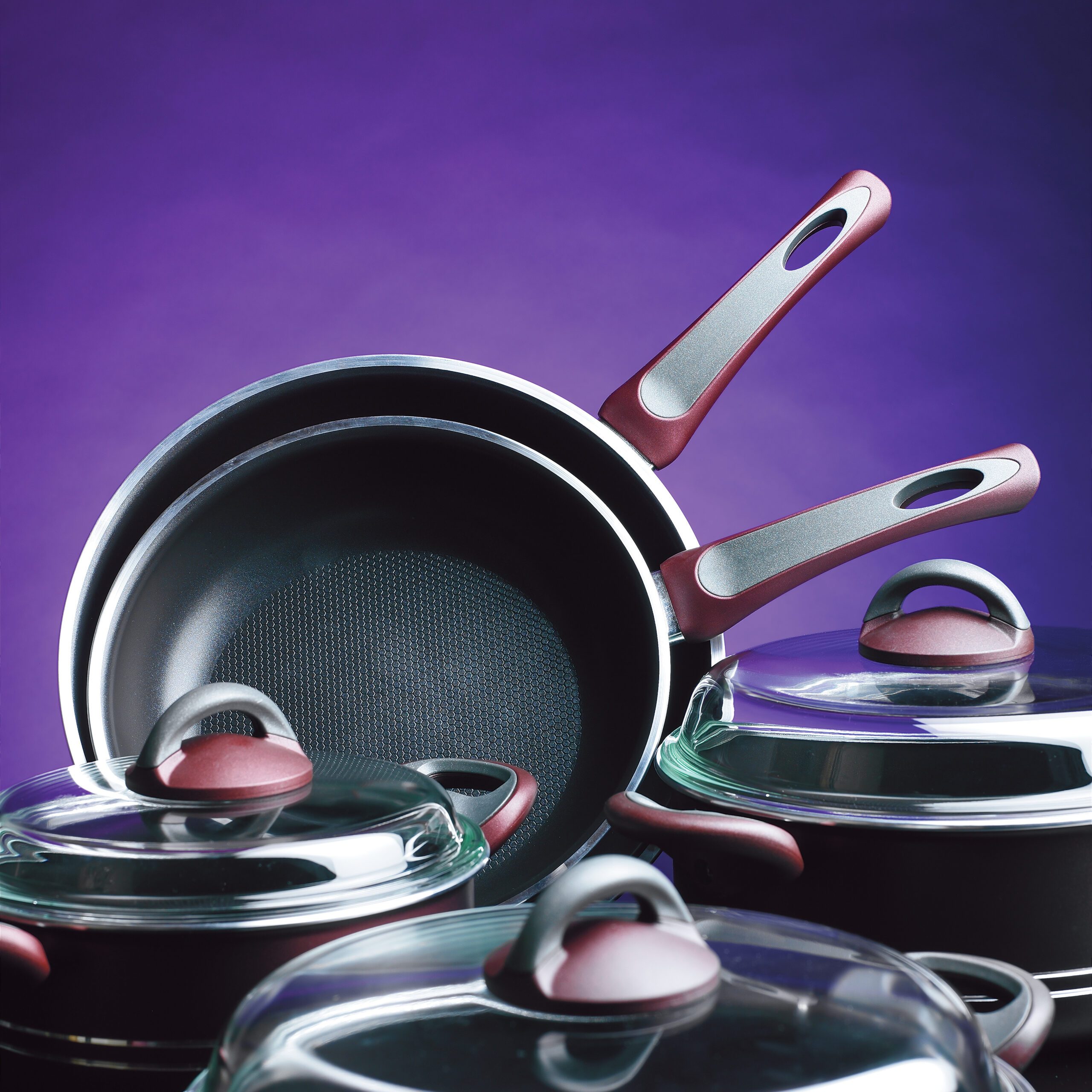 Set Of Black Non Stick pots and pans On A Purple Background