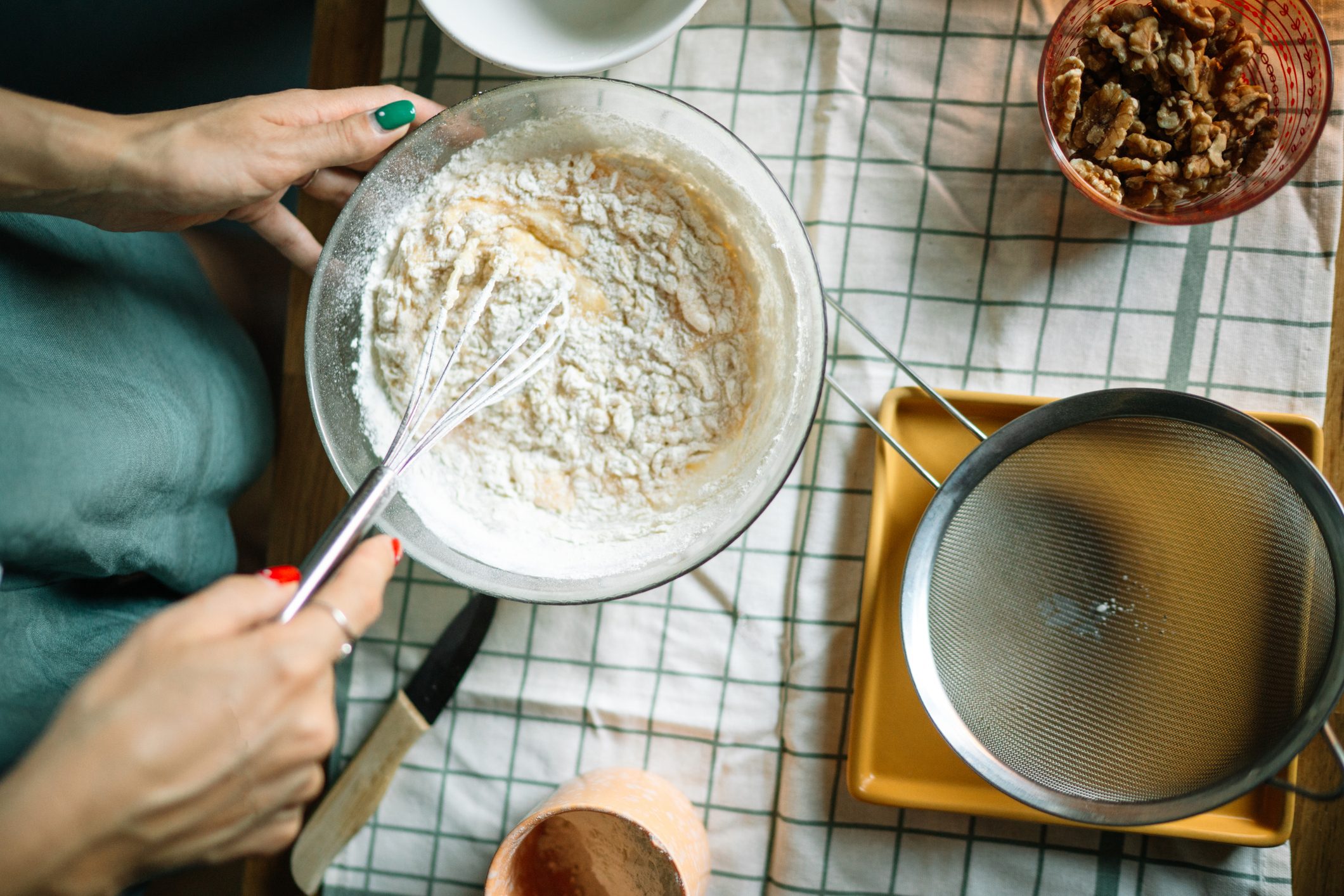 High angle view of woman holding whisk and bowl for baking