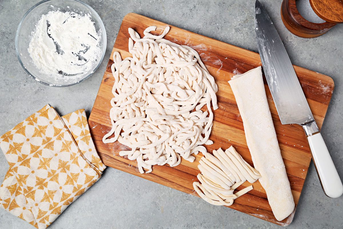 Rolled out dough sliced into noodles.